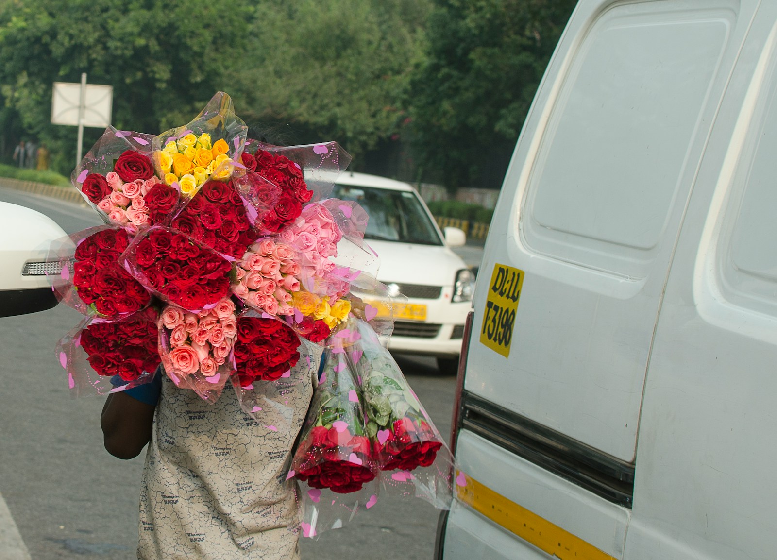 A woman walking down a street holding a bouquet of flowers