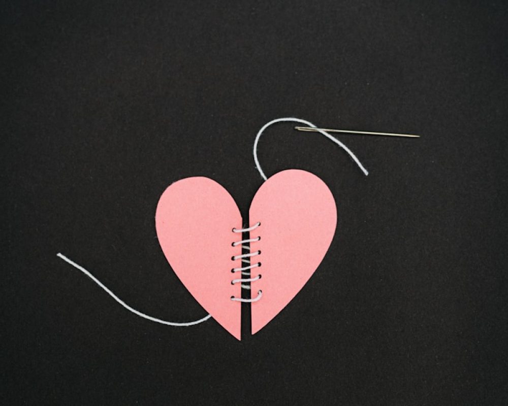 a broken heart with a string attached to it