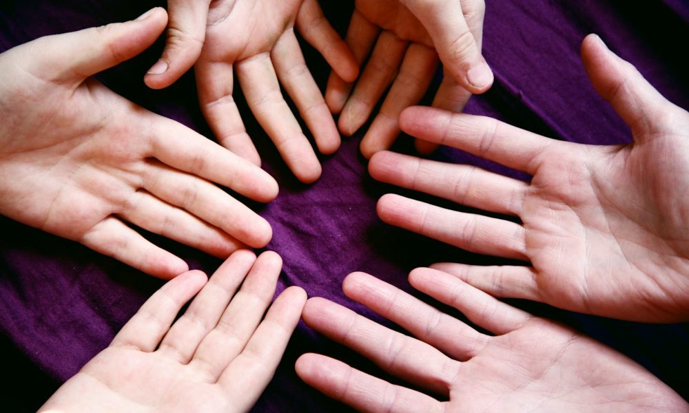 persons left hand on purple textile