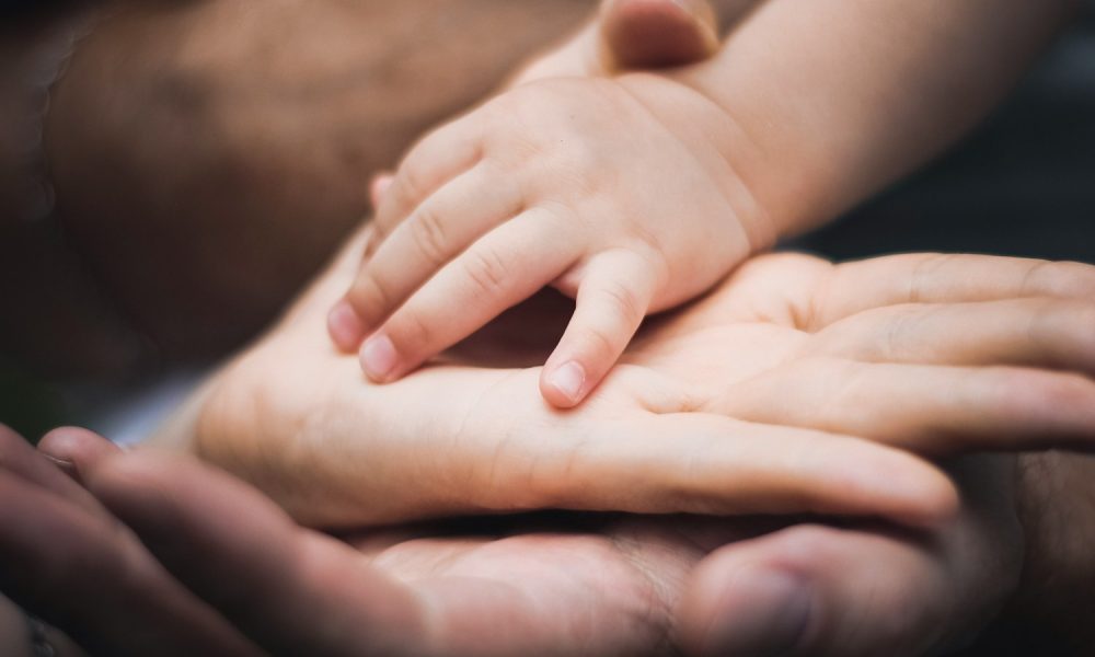 baby's hand on mother and father palms
